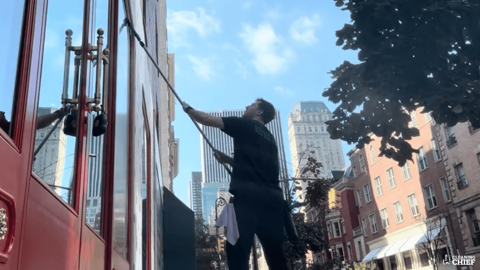 Window cleaner wiping large glass storefront in New York City for a streak-free finish